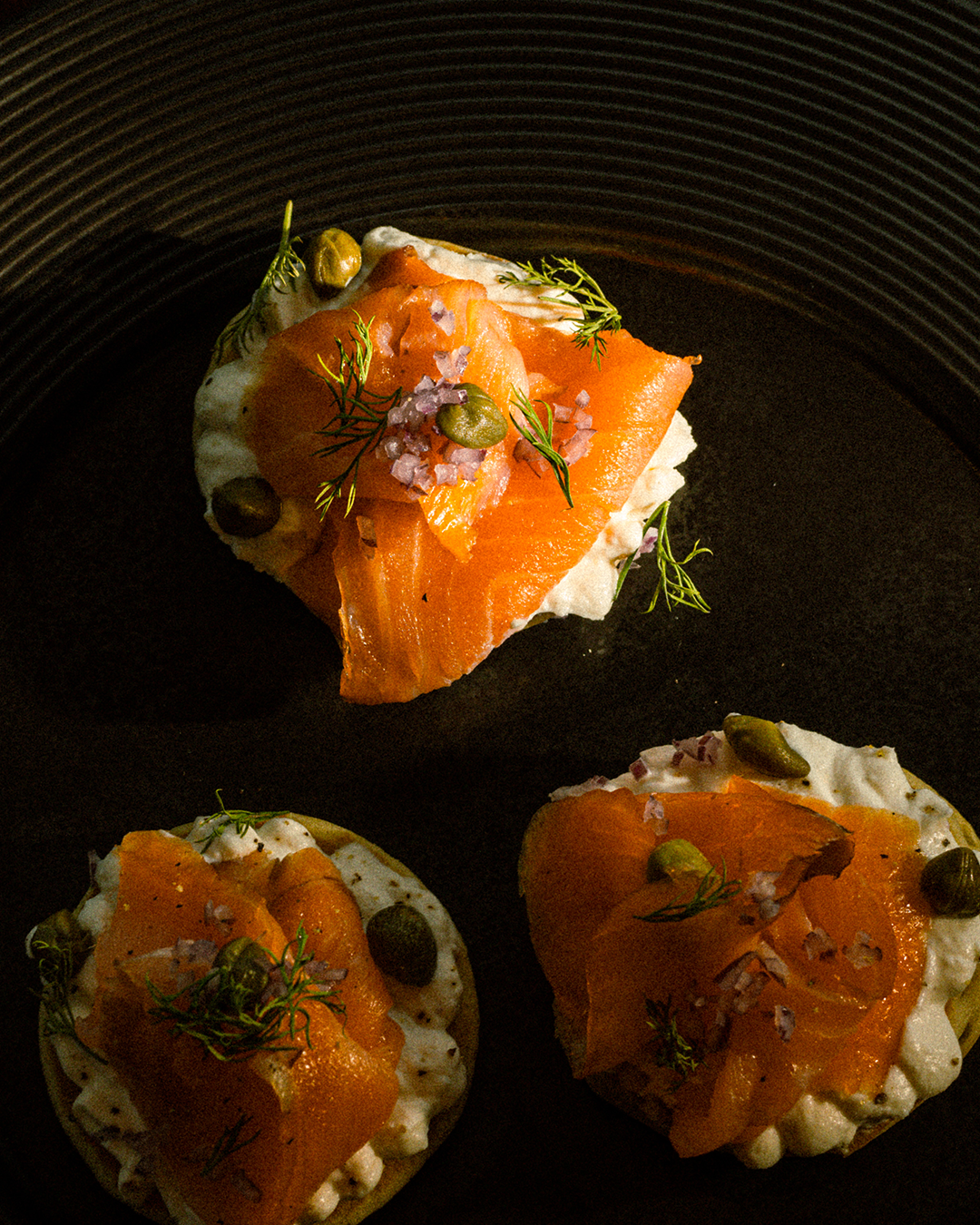 Smoked salmon bites plated on a dark dish