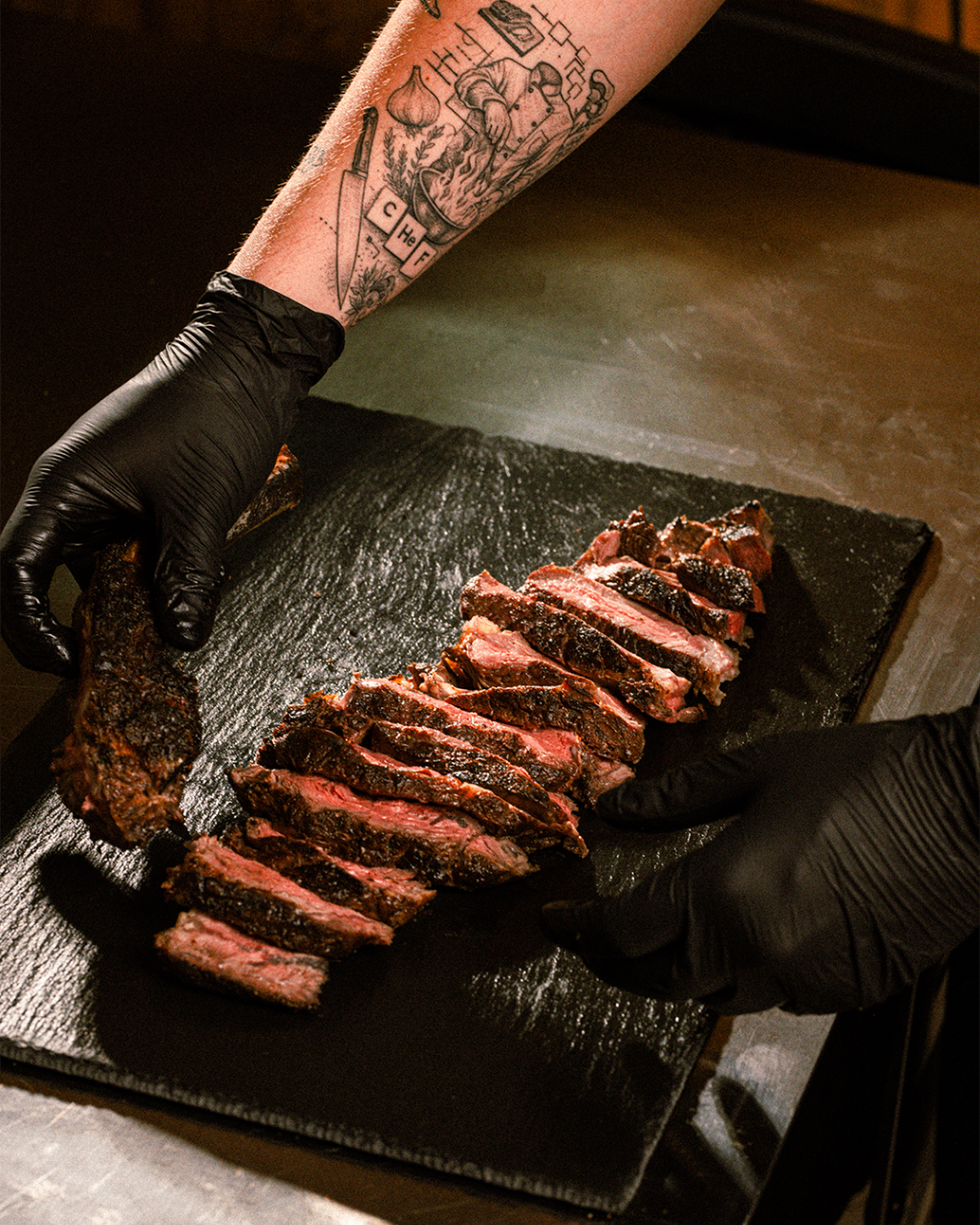 Plated sliced steak on a dark serving board